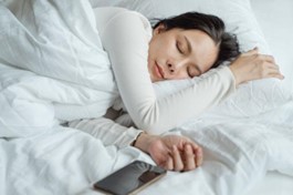 A woman sleeping near her phone